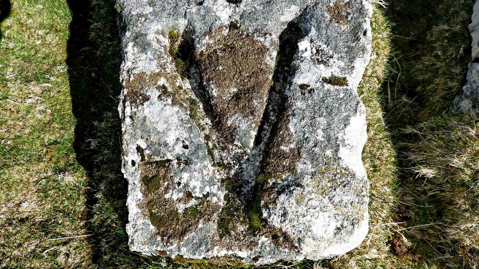 The top ends of the Vees terminate in a round hole drilled into the stone